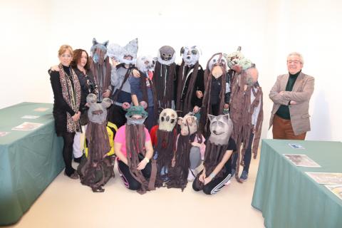 El alumnado posa con las máscaras de la exposición