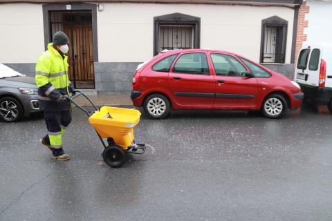 Un operario esparce sal en las calles