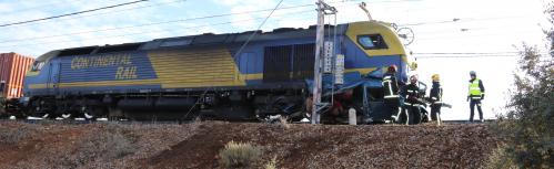 Los bomberos trabajan para extraer la furgoneta atrapada bajo la locomotora